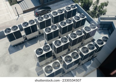 Top view. Large row of buildings with rooftop fans used in air conditioning, refrigeration, heat pump systems, future green energy concept.