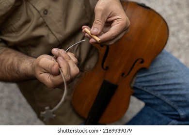 Top view of a Latin American luthier placing in a special tool a sound post that is placed inside the instrument by pressure between the top and the bottom of the violin. Stringed instruments concept