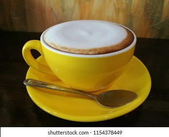 Top view latte art coffee in yellow cup of coffee on wooden table vintage background - Shutterstock ID 1154378449