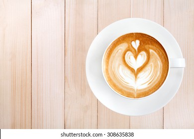 Top view latte art coffee on wood background