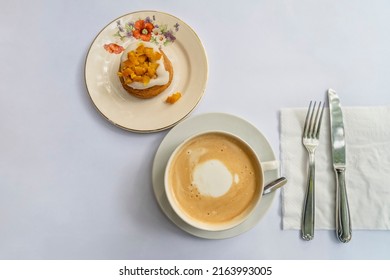 Top View Of A Latte And An Orange Cupcake On Vintage Crockery