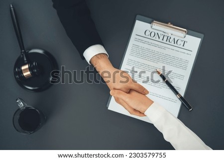 Top view lawyer or attorneys colleagues handshake after successful legal discussing on contract agreement for lawsuit to advocate resolves dispute in court ensuring trustworthy partner. Equilibrium