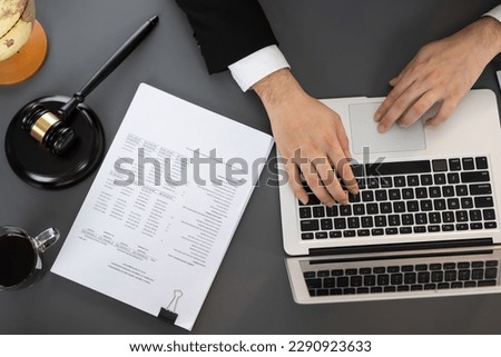 Top view lawyer or judge working on his desk with laptop at law firm or court, drafting legal documents with fairness and ethical judgment for lawsuits and litigation. Equilibrium