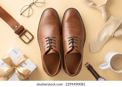 Top view layout. Honor Dad's sophistication with leather shoes, necktie, wristwatch, glasses, belt, giftbox with ribbon bow, coffee cup, men's accessories on a beige background - Shutterstock ID 2299490081