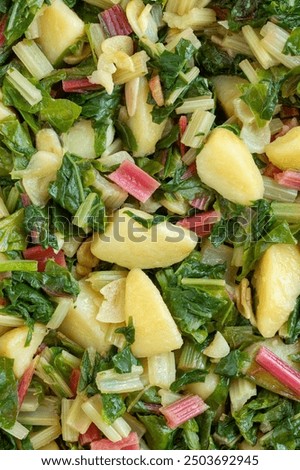 Top view of leaf beet with potato, South Croatian Blitva dish. Background texture. The dish is made with boiled potatoes, swiss chard, garlic, and olive oil. 