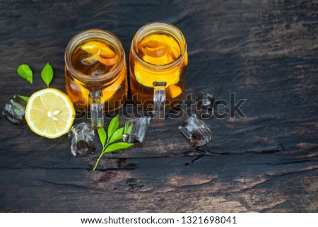 top view long Iced tea with lemon slices on wood background