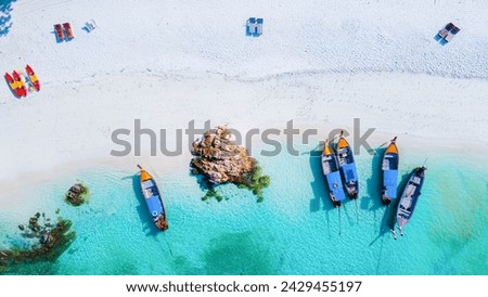  top view at longtail boats on the beach of Koh Lipe Island Thailand, tropical vacation background, colorful turqouse colored ocean drone view