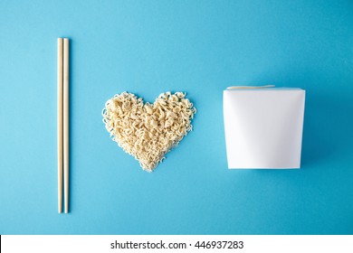 Top View I Love Wok Takeaway Noodles Presentation With Chopsticks, Blank Box And Dry Pasta In Heart Shape Isolated On Blue Mockup