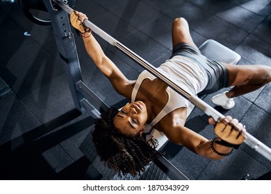 Top View Of A Lovely Tranquil Female Weightlifter Doing The Bench Press At The Gym