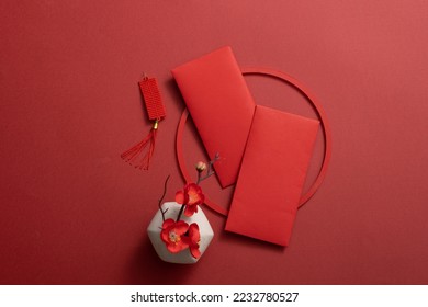Top view of lucky envelopes and decorative items for Chinese lunar new year on red background. Space for text