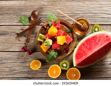 Top View Of  Luscious Healthy Eating, With Kiwi Fruit, Cherry, Watermelon, Oranges, Mint And Honey On A Rustic Background