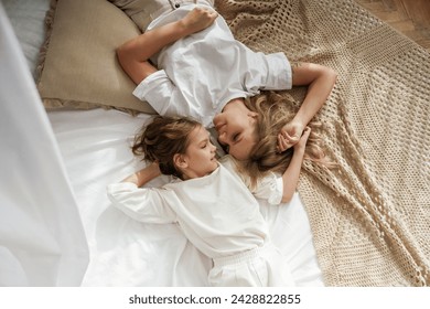 Top view, lying down on the bed. Mother with daughter are at home together. - Powered by Shutterstock