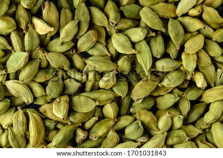 Top view macro closeup on plenty of green cardamom spice, horizontal format