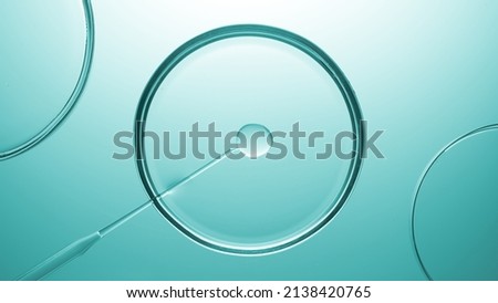 Top view macro shot of lab dropper injects insoluble transparent gel in liquid in petri dish on cyan background | Abstract skincare products formulating concept