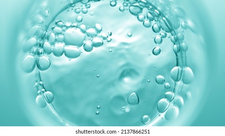 Top view macro shot of transparent liquid pouring into beaker creates a lot of bursting bubbles on cyan background | Abstract face care cosmetics formulation concept - Shutterstock ID 2137866251