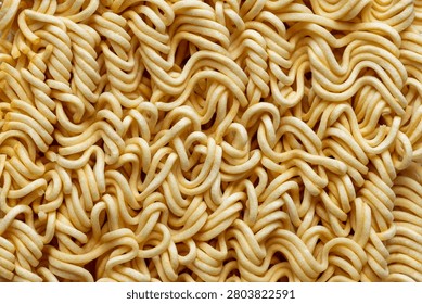 Top View Macro Texture of Uncooked Instant Noodle Block,A detailed close-up shot focusing on the intricate wavy texture of an uncooked instant noodle block, highlighting the pattern of dried wheat dough strands.