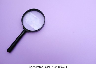 top view magnifying glass on the on a purple background