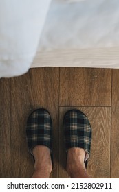 Top View Of Male Feet In Plaid Slippers In Bedroom Next To The Bed