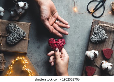 Top View Of Male And Female Hands Holding Red Gift Box With Golden Ribbon On Pink Background Flat Lay. Present For Birthday, Valentine Day, Christmas, New Year.