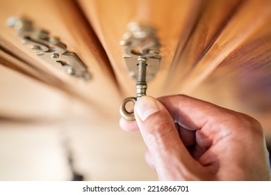 Top view of male hand puts the key in the keyhole of a clothes closet - Shutterstock ID 2216866701