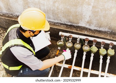 Top view male plumber wearing a mask checks the water meter used in the condominium building, records the monthly water usage work and checks the integrity of the equipment to be ready for use.