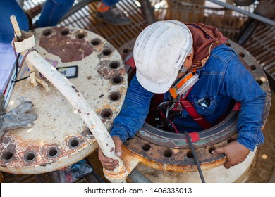 Top view male worker climb down the stairs into the tank spherical propane tank area confined space safety blower fresh air