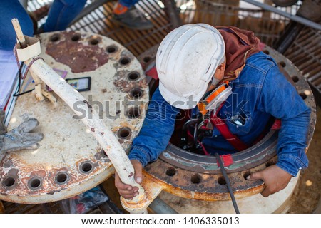 Top view male worker climb down the stairs into the tank spherical propane tank area confined space safety blower fresh air