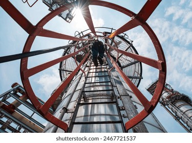 Top view male worker climbs up the ladder inspection stainless tank work at height safety - Powered by Shutterstock