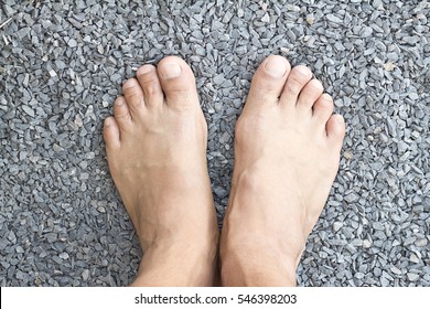 Top View Of Man Bare Feet In Rocks