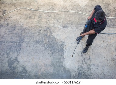 Top View, Man Cleaning Floor With High Pressure Water Jet.