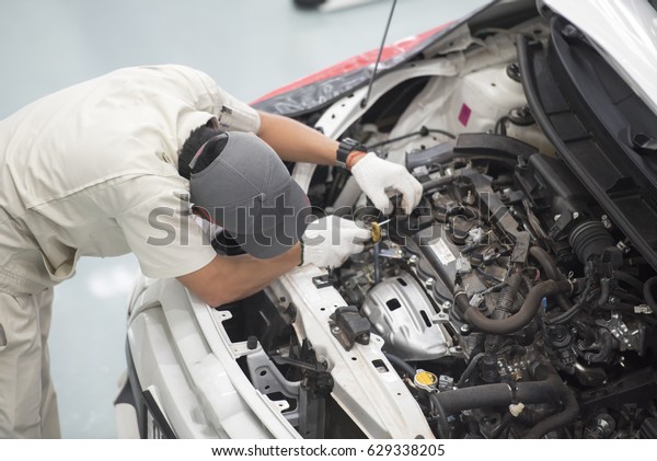 Top view a\
man fixing a car engine in his\
garage