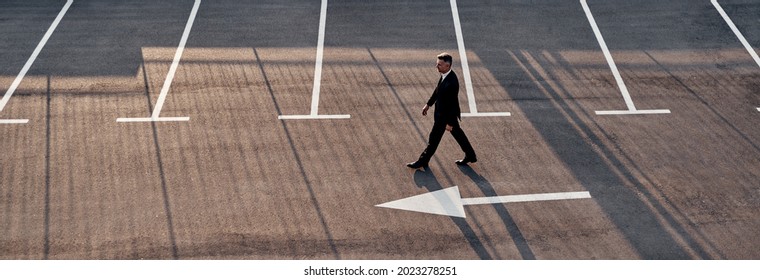 Top View Of Man In Formalwear Moving Forward With Arrow Sign On The Road