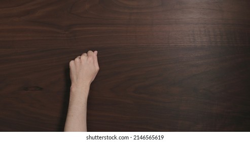 Top View Man Hand Knock On Black Walnut Table With Copy Space