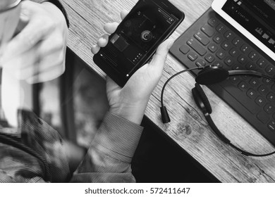 top view of man hand using VOIP headset with digital tablet computer docking keyboard,smart phone, communication, it support, call center and customer service help desk on wooden table,black and white