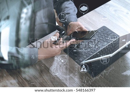 top view of man hand using VOIP headset with digital tablet computer docking keyboard,smart phone,it support, call center and customer service help desk on wooden table,virtual interface icons screen