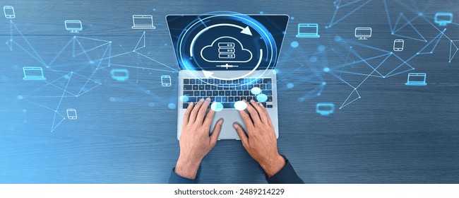 Top view of man hands typing on computer keyboard, cloud service hologram hud on screen, files transfer between devices. Concept of data share and synchronization