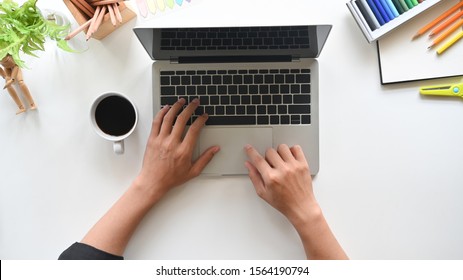 Top View Man Hands Working On Modern Laptop. Office Desktop On White Table.