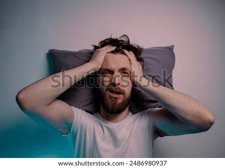 Top view man having trouble sleeping  head on a pillow hands on the head 