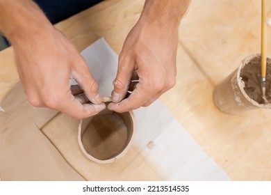 Top View Of Man Modeling Clay Piece In Circle Shape During Pottery Class