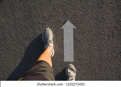 Top View Of Man Wearing Shoes Choosing A Way Marked With Arrows. Chooses The Right Path Concept.