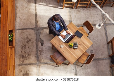 Top View Of A Man Working On His Laptop In Beautiful Office Interior