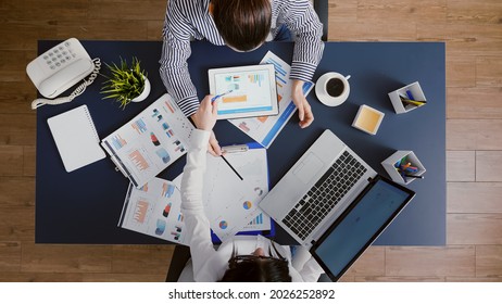 Top View Of Managers Women Discussing Financial Accounting Paperwork During Company Meeting Working In Startup Office. Business Teamwork Analyzing Management Strategy Brainstorming Ideas