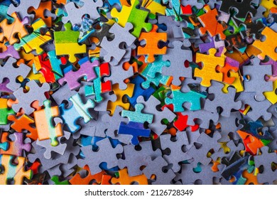 Top view many jigsaw puzzle pieces over the entire frame. A background image of scattered colorful puzzle pieces - Shutterstock ID 2126728349