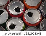 A top view of many opened aluminium cans of beer or soda. One of them is with american flag print