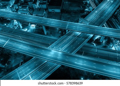 Top view of massive expressway at night with light of cars, transportation industrial concept.