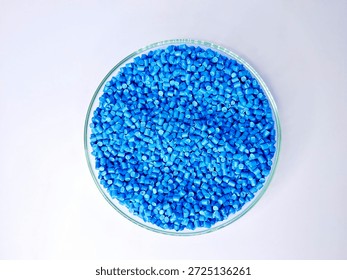 Top view, masterbatch granules, polymer carrying pigment poured into a glass cup forming a circle with a white background, as a product catalog design for a plastic industry company profile