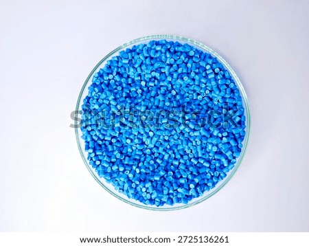 Top view, masterbatch granules, polymer carrying pigment poured into a glass cup forming a circle with a white background, as a product catalog design for a plastic industry company profile