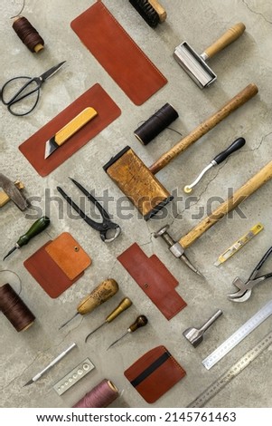 Top view materials and instruments on cutting mat for chopping measurement leatherwork details. Process of handwork manufacturing with equipment exclusive quality stuff at leather workshop