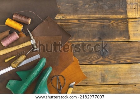 Top view materials and instruments on cutting mat for chopping measurement leatherwork details. Process of handwork manufacturing with equipment exclusive quality stuff at leather workshop