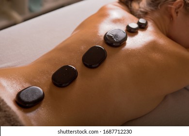 Top view of mature woman relaxing during hot stone massage - Powered by Shutterstock